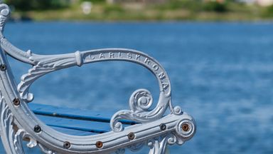 Metal bench with ocan in background