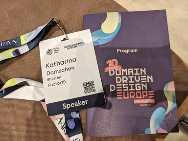 The program and Katharina's conference badge for Domain-Driven Design Europe